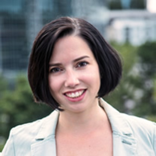 Penny Kronz, white woman with dark brown hair, brown eyes and wearing a white shirt.